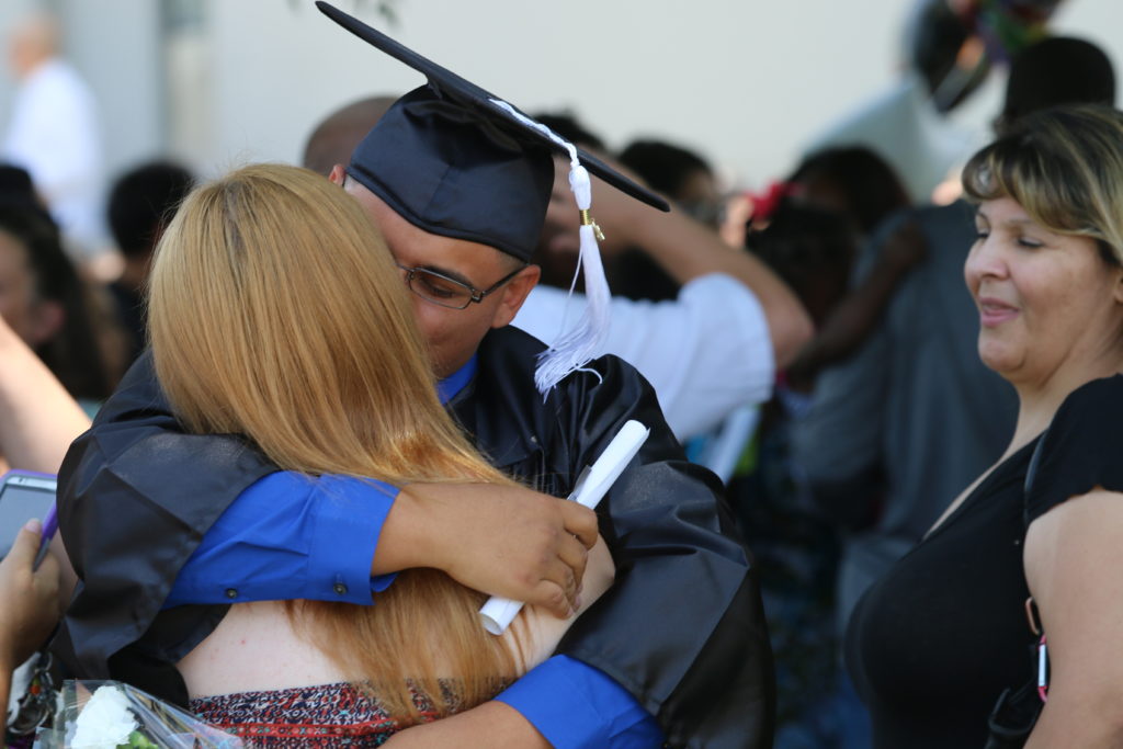 Graduate hugging loved one
